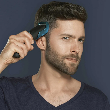 Hombre cortándose el pelo con una máquina cortapelos eléctrica